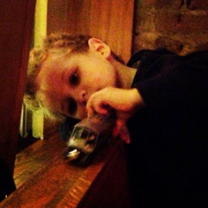 Mylo alternates between playing with his new "M" train and taking bites of pasta